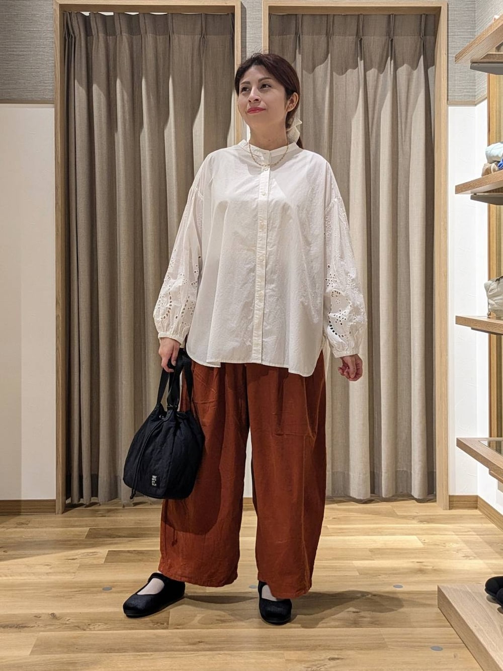 オレンジ系のその他パンツ、ブラック系のその他シューズ、ホワイト系のシャツ/ブラウスを着用したレディースの秋コーディネートの1枚目の写真