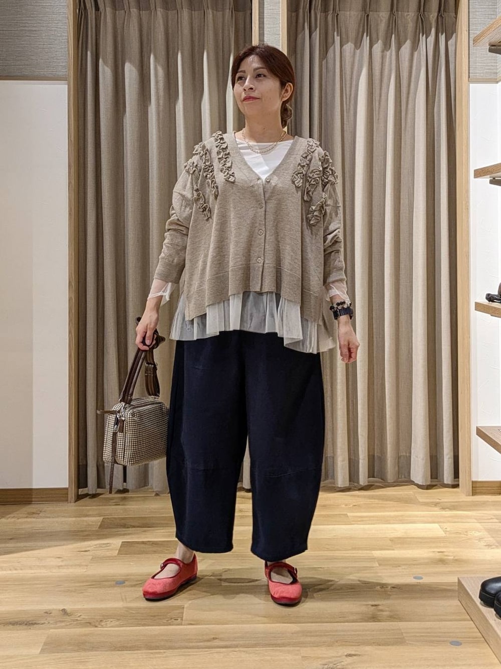 レッド系のその他シューズ、その他のTシャツ/カットソー、ベージュ系のカーディガン/ボレロを着用したレディースの秋コーディネートの1枚目の写真
