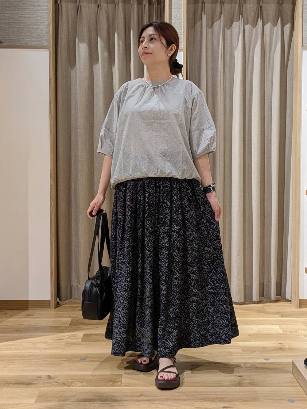 ブラック系のショルダーバッグ、グレー系のシャツ/ブラウス、ブラウン系のサンダルを着用したレディースの夏コーディネートの1枚目の写真