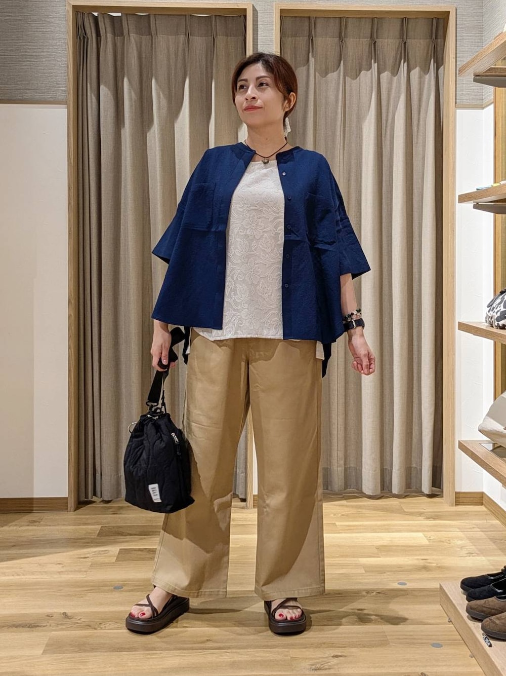 ブラック系のショルダーバッグ、ブラウン系のサンダル、グレー系のタンクトップを着用したレディースの夏コーディネートの1枚目の写真