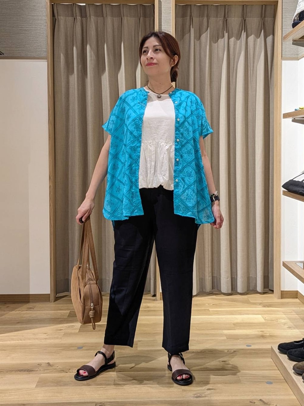 ブラウン系のショルダーバッグ、ブルー系のその他パンツ、ブラウン系のサンダルを着用したレディースの夏コーディネートの1枚目の写真
