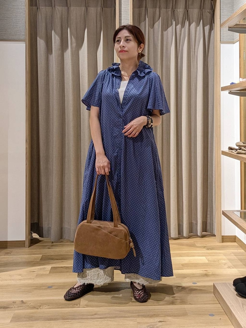 ブラウン系のショルダーバッグ、ベージュ系のデニムパンツ、ブラウン系のパンプスを着用したレディースの秋コーディネートの1枚目の写真
