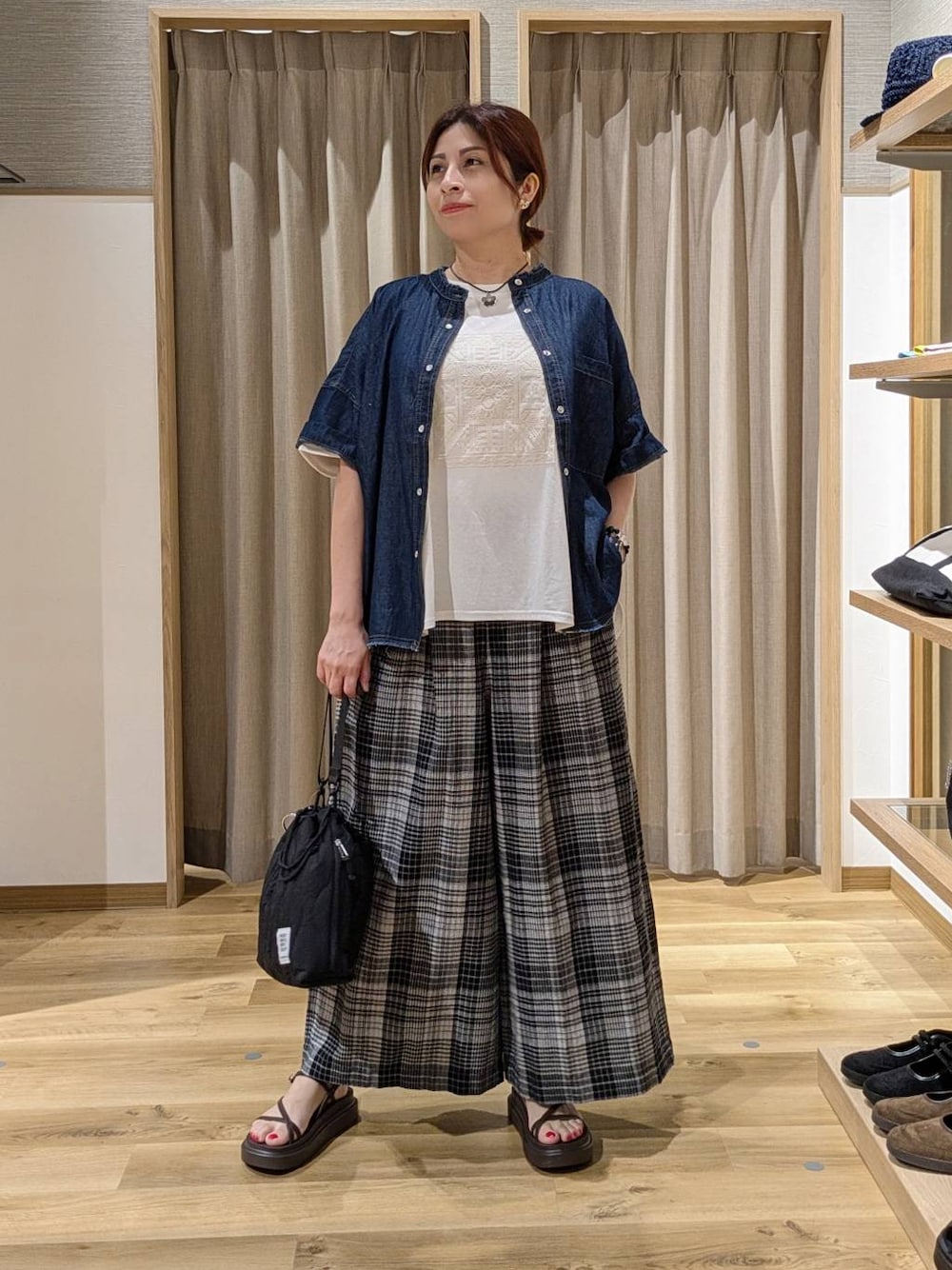 ブラック系のショルダーバッグ、ブラウン系のサンダル、ホワイト系のその他パンツを着用したレディースの夏コーディネートの1枚目の写真