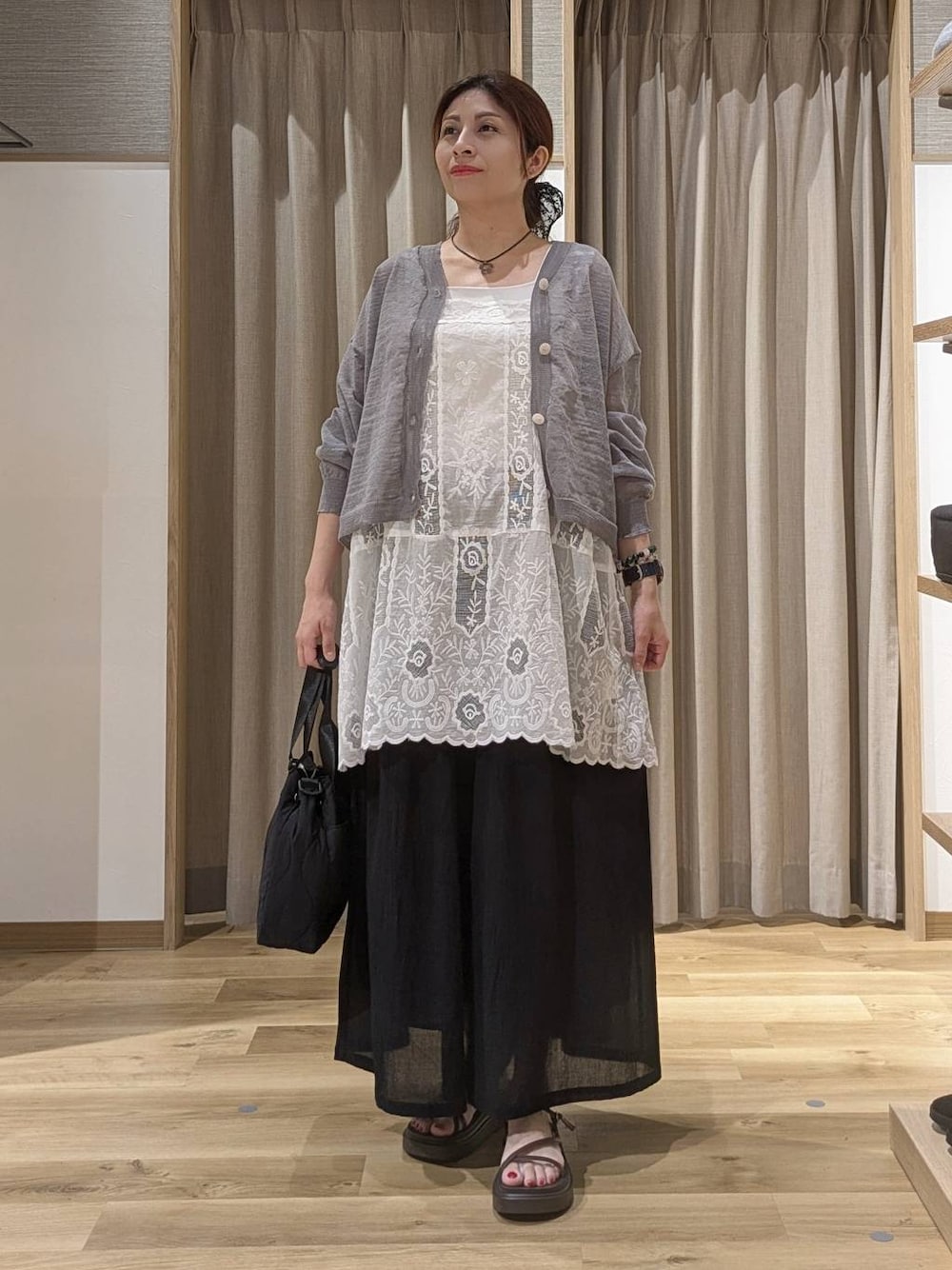 ブラック系のその他パンツ、ホワイト系のチュニック、ブラウン系のサンダルを着用したレディースの夏コーディネートの1枚目の写真
