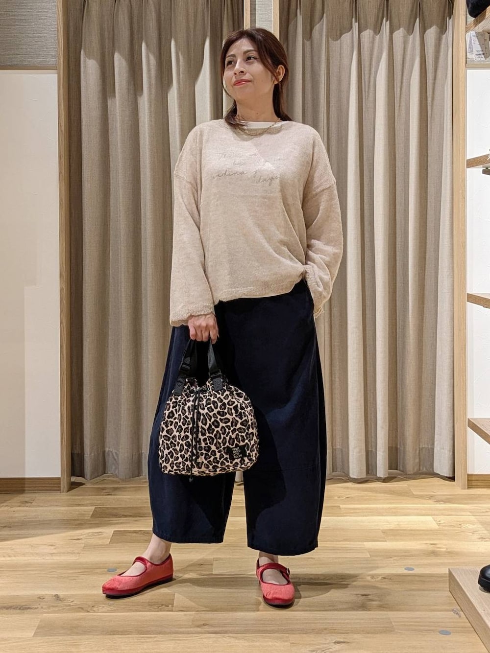 レッド系のその他シューズ、ベージュ系のニット/セーター、ホワイト系のTシャツ/カットソーを着用したレディースの秋コーディネートの1枚目の写真