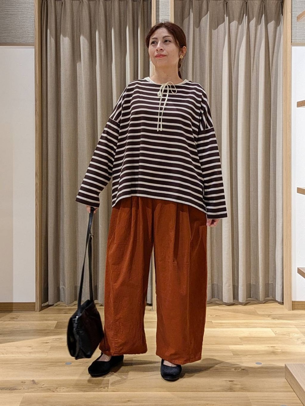 オレンジ系のその他パンツ、ブラック系のその他シューズ、ベージュ系のシャツ/ブラウスを着用したレディースの秋コーディネートの1枚目の写真