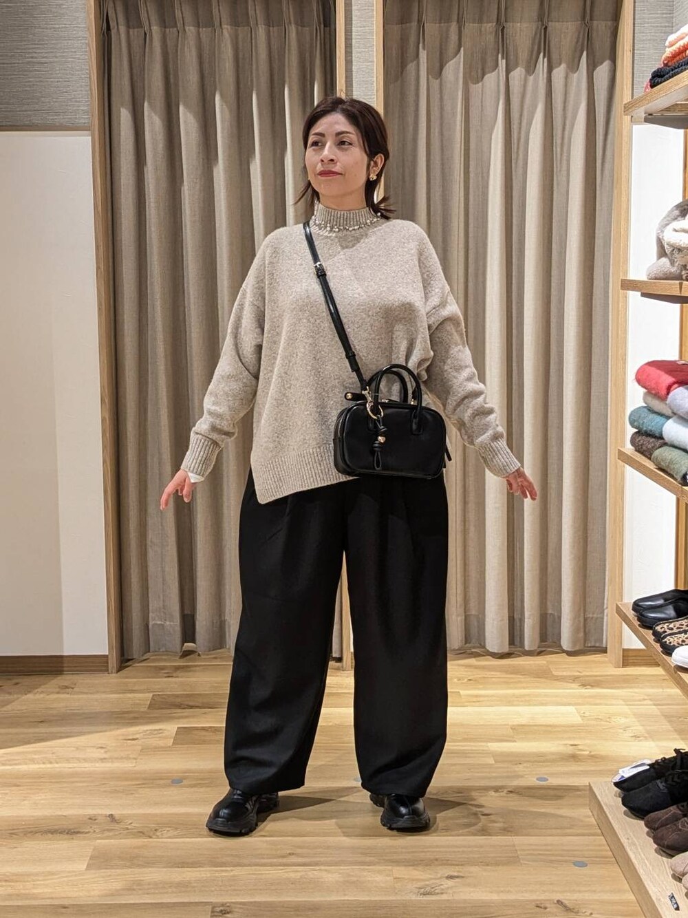 ブラック系のブーツ、ブラック系のその他パンツ、ベージュ系のニット/セーターを着用したレディースの冬コーディネートの1枚目の写真