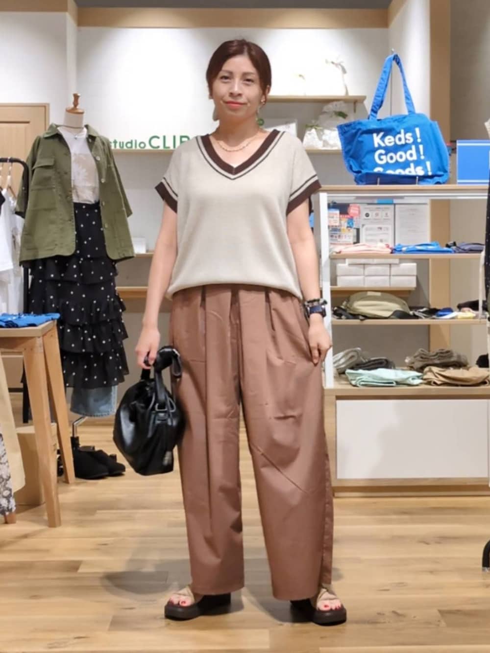 ベージュ系のニット/セーター、ベージュ系のサンダル、ブラック系のトートバッグを着用したレディースの夏コーディネートの1枚目の写真