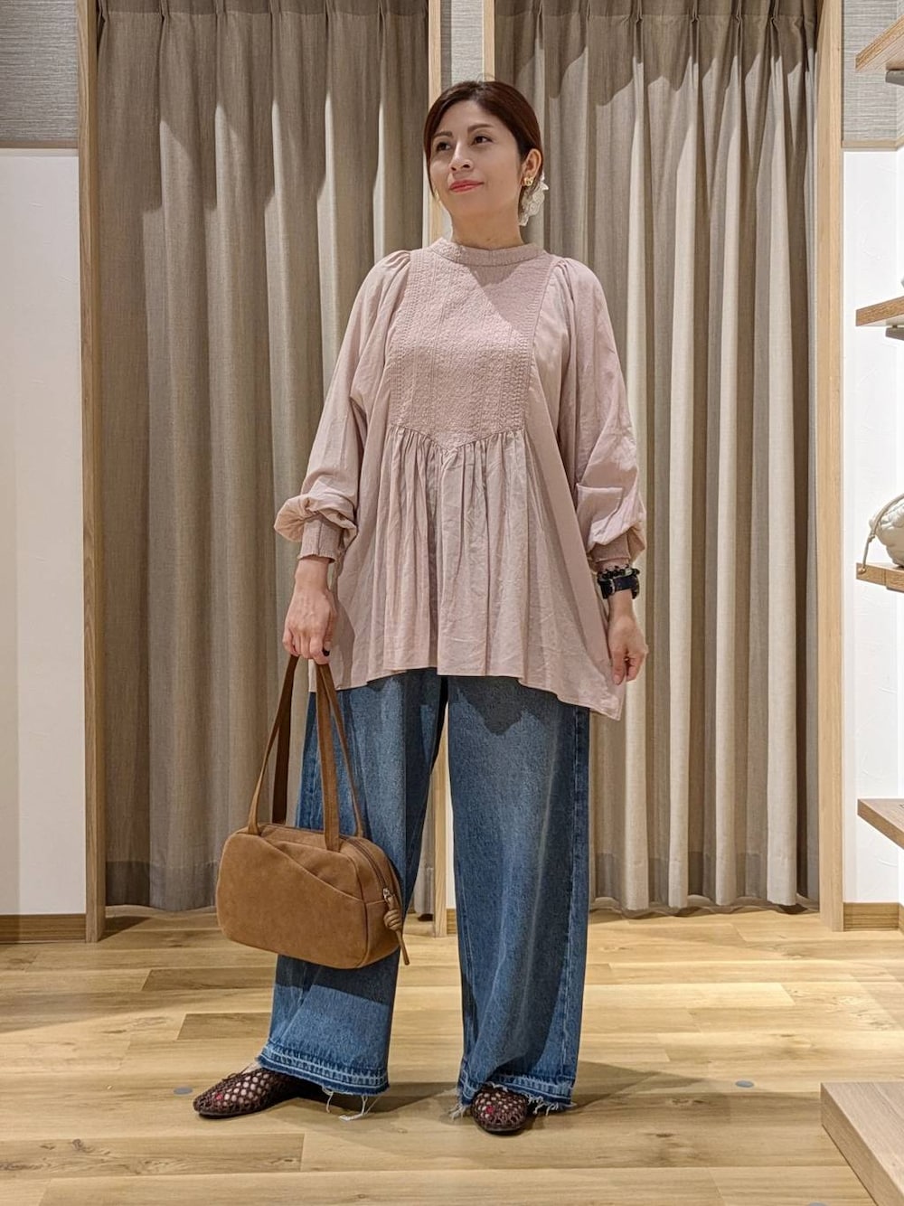 ブラウン系のショルダーバッグ、ピンク系のシャツ/ブラウス、ブラウン系のパンプスを着用したレディースの秋コーディネートの1枚目の写真