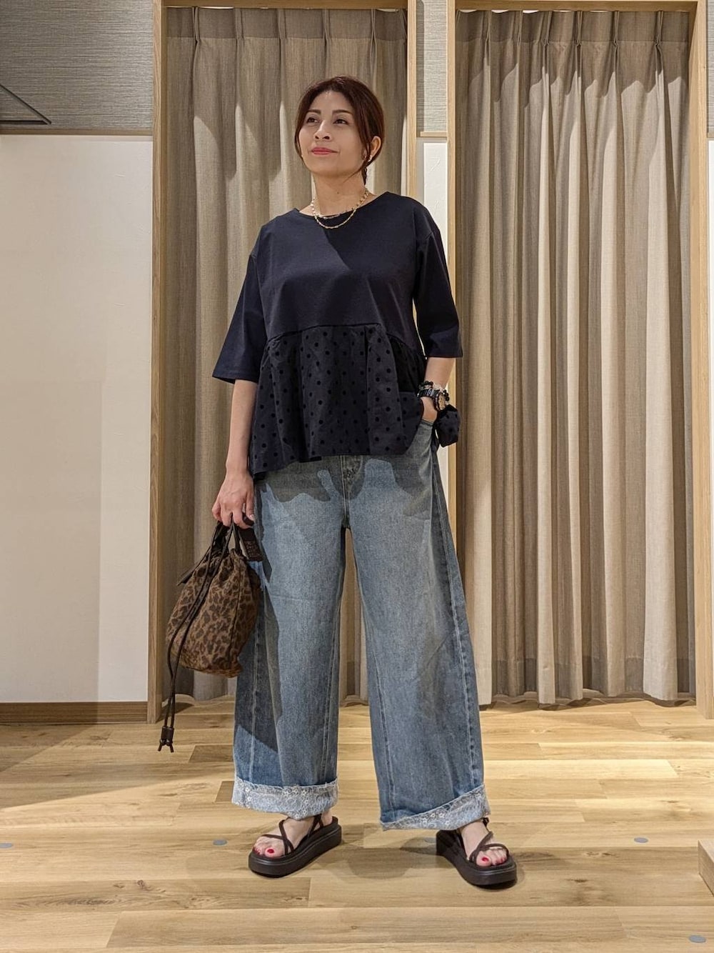 ブルー系のデニムパンツ、ブルー系のTシャツ/カットソー、ブラウン系のショルダーバッグを着用したレディースの夏コーディネートの1枚目の写真