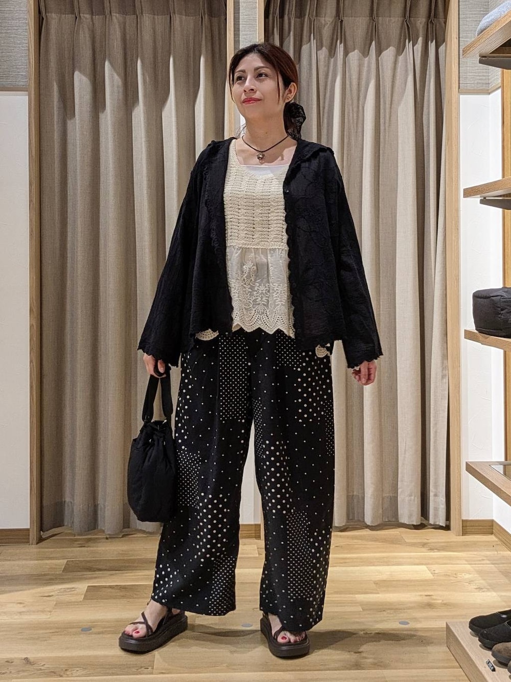 ベージュ系のベスト、ブラック系のシャツ/ブラウス、ブラウン系のサンダルを着用したレディースの夏コーディネートの1枚目の写真