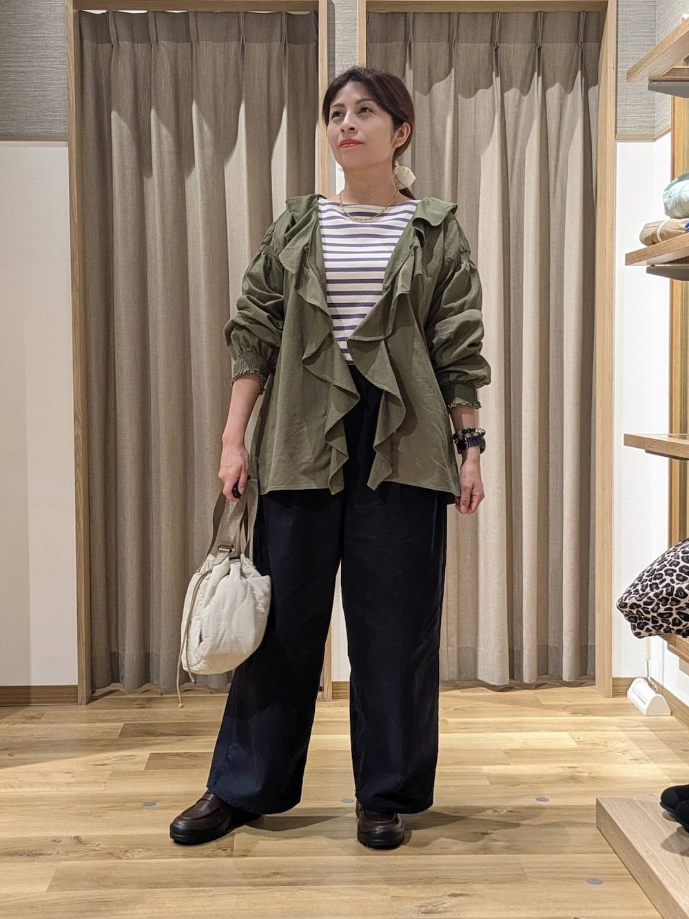 グリーン系のシャツ/ブラウス、その他のTシャツ/カットソー、ブラウン系のローファーを着用したレディースの秋コーディネートの1枚目の写真