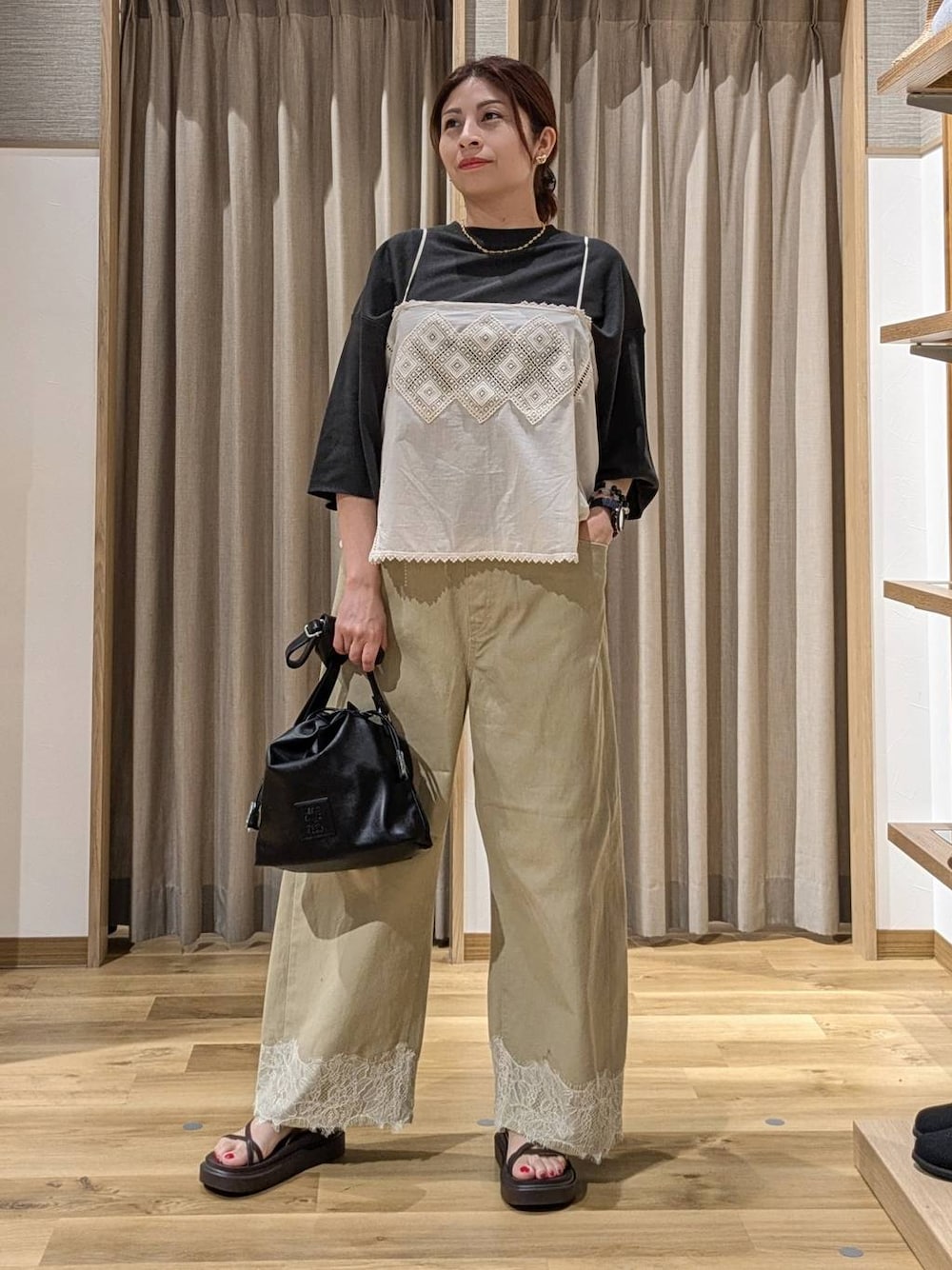 ベージュ系のデニムパンツ、ベージュ系のキャミソール、ブラウン系のサンダルを着用したレディースの夏コーディネートの1枚目の写真