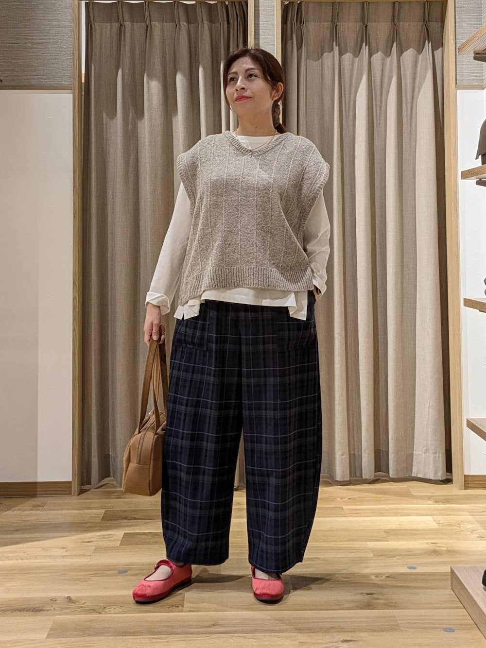 ブラウン系のショルダーバッグ、レッド系のその他シューズ、ホワイト系のTシャツ/カットソーを着用したレディースの秋コーディネートの1枚目の写真