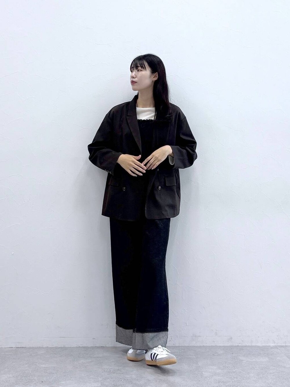 ブルー系のデニムパンツ、ホワイト系のTシャツ/カットソー、ブラウン系のテーラードジャケットを着用したレディースの秋コーディネートの1枚目の写真
