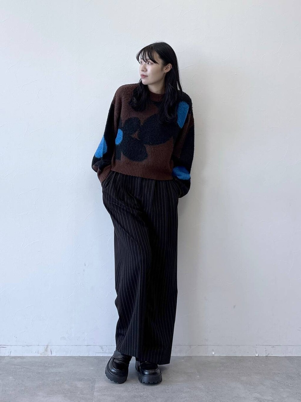 ブラック系のローファー、ブラウン系のニット/セーター、ブラック系のスラックスを着用したレディースの秋コーディネートの1枚目の写真