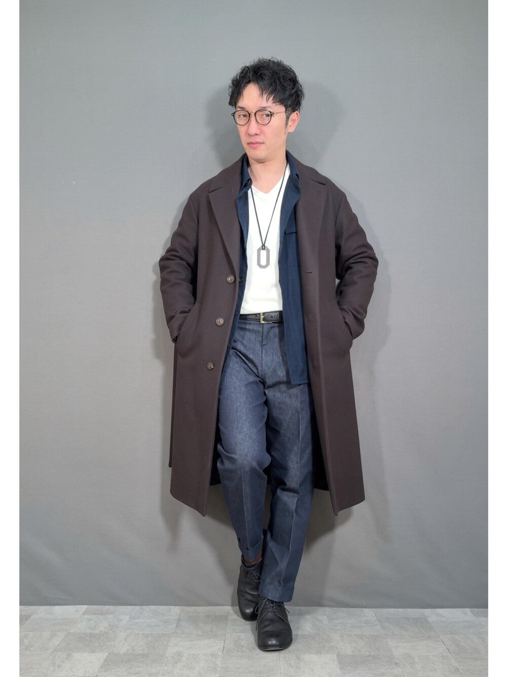 ブラウン系のジャケット/アウター、ブルー系のスラックス、ブラック系のドレスシューズを着用したメンズの冬コーディネートの1枚目の写真