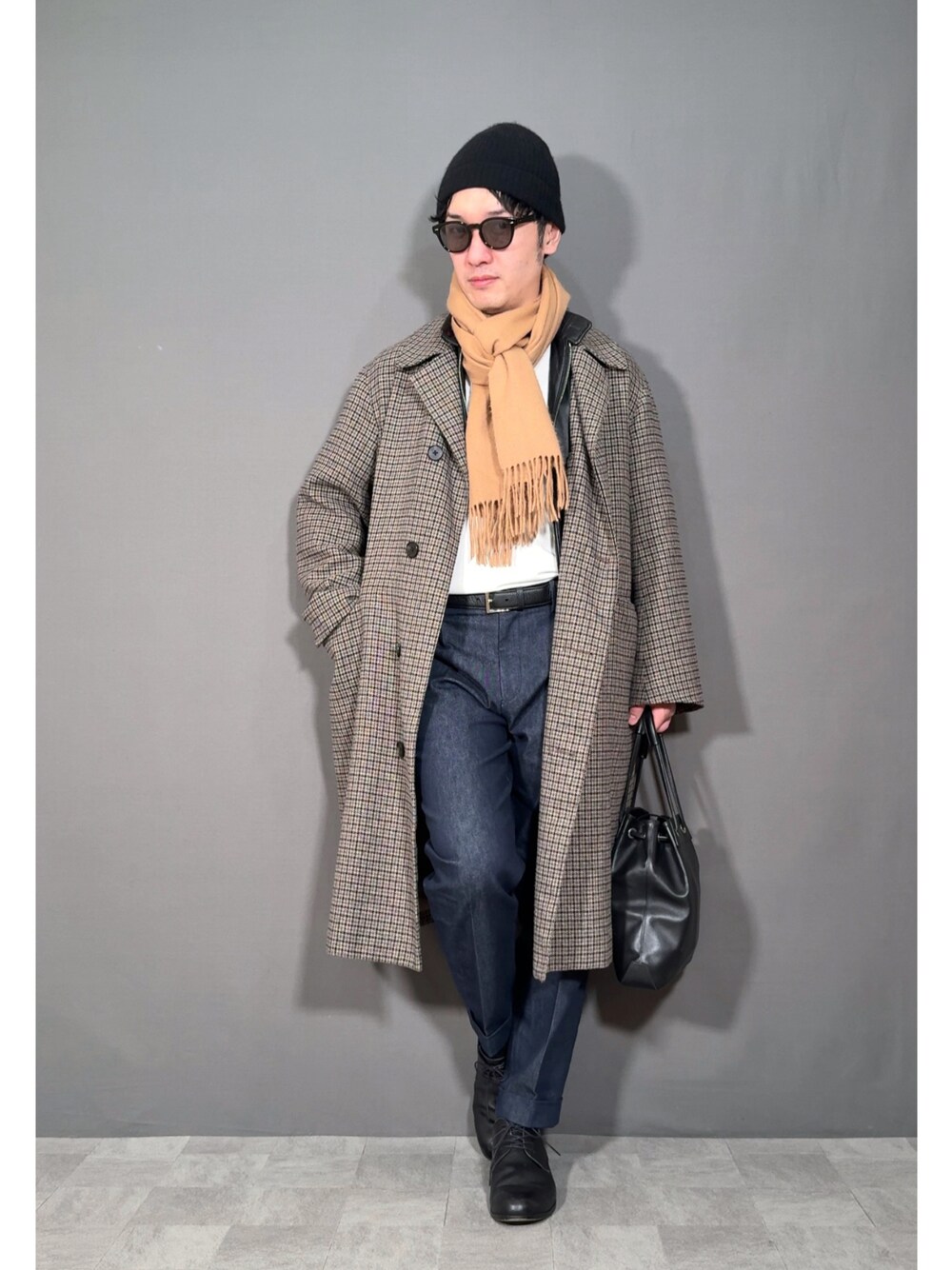 ベージュ系のステンカラーコート、ブルー系のスラックス、ブラック系のドレスシューズを着用したメンズの冬コーディネートの1枚目の写真