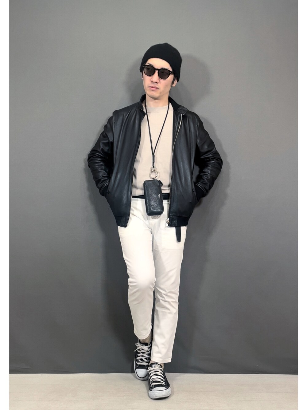 ホワイト系のスラックス、ブラック系のスニーカー、ブラック系のニットキャップ/ビーニーを着用したメンズの冬コーディネートの1枚目の写真