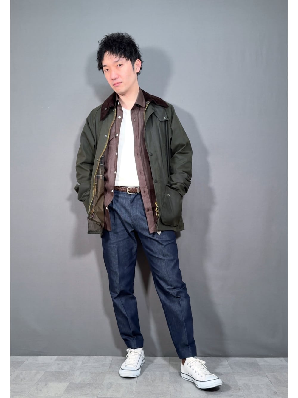 グリーン系のジャケット/アウター、ブルー系のデニムパンツ、ホワイト系のスニーカーを着用したメンズの春コーディネートの1枚目の写真