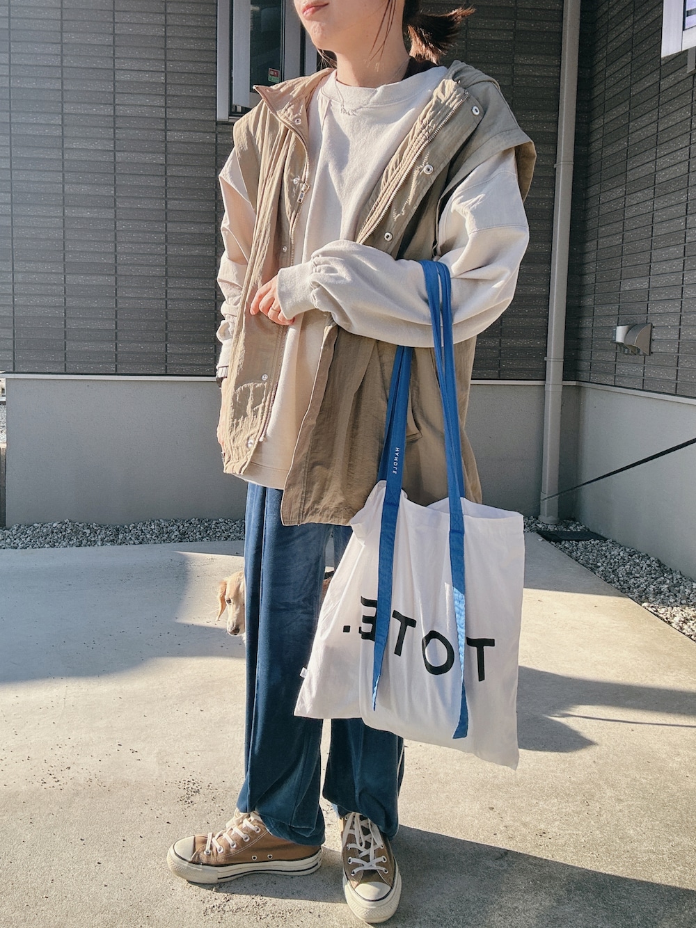 グレー系のスウェット、ブルー系のトートバッグ、ブラウン系のスニーカーを着用したレディースの秋コーディネートの1枚目の写真