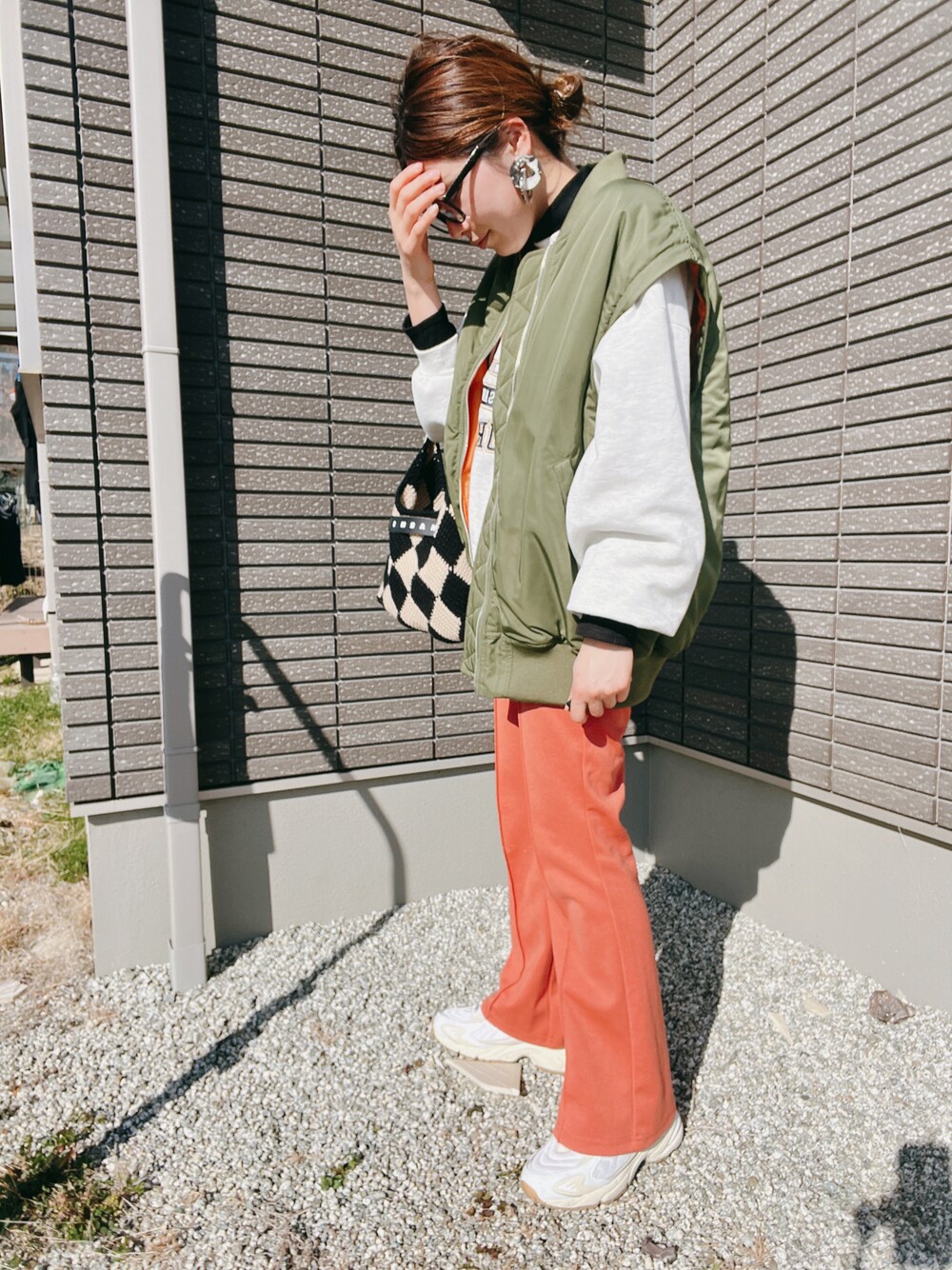 グリーン系のMA-1、ブラック系のTシャツ/カットソー、オレンジ系のその他パンツを着用したレディースの冬コーディネートの1枚目の写真