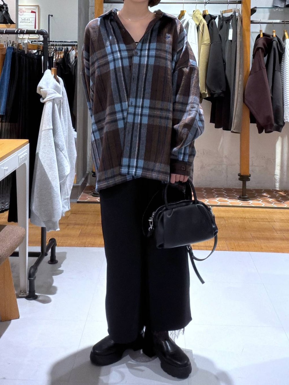 ブラック系のその他パンツ、ブラック系のショルダーバッグ、ブラック系のブーツを着用したレディースの秋コーディネートの1枚目の写真
