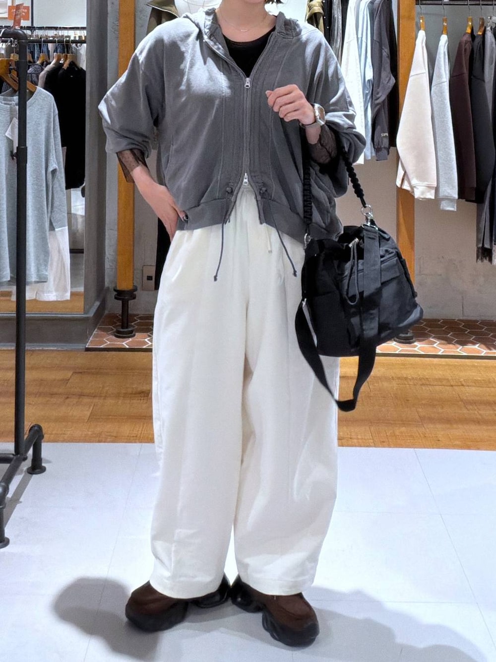 グレー系のパーカー、ブラウン系のスニーカー、ブラック系のTシャツ/カットソーを着用したレディースの秋コーディネートの1枚目の写真