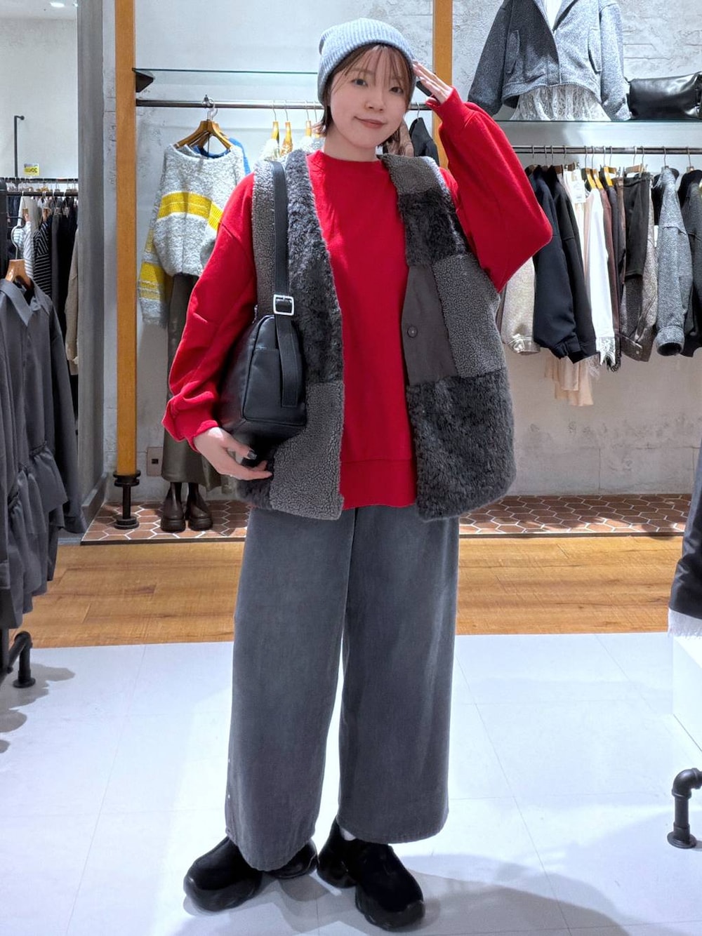 グレー系のデニムパンツ、ブラック系のスニーカー、レッド系のスウェットを着用したレディースの秋コーディネートの1枚目の写真