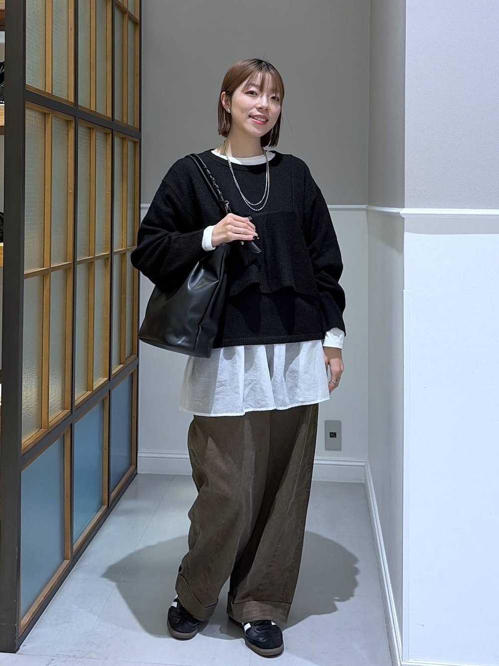 ホワイト系のTシャツ/カットソー、ブラック系のトートバッグ、ブラウン系のその他パンツを着用したレディースの冬コーディネートの1枚目の写真