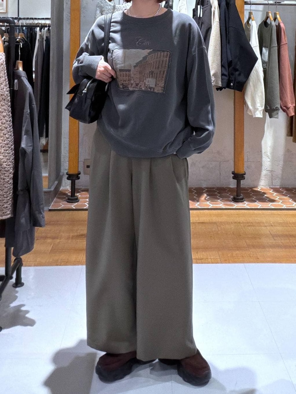 ブラック系のボストンバッグ、グリーン系のその他パンツ、ブラウン系のスニーカーを着用したレディースの秋コーディネートの1枚目の写真