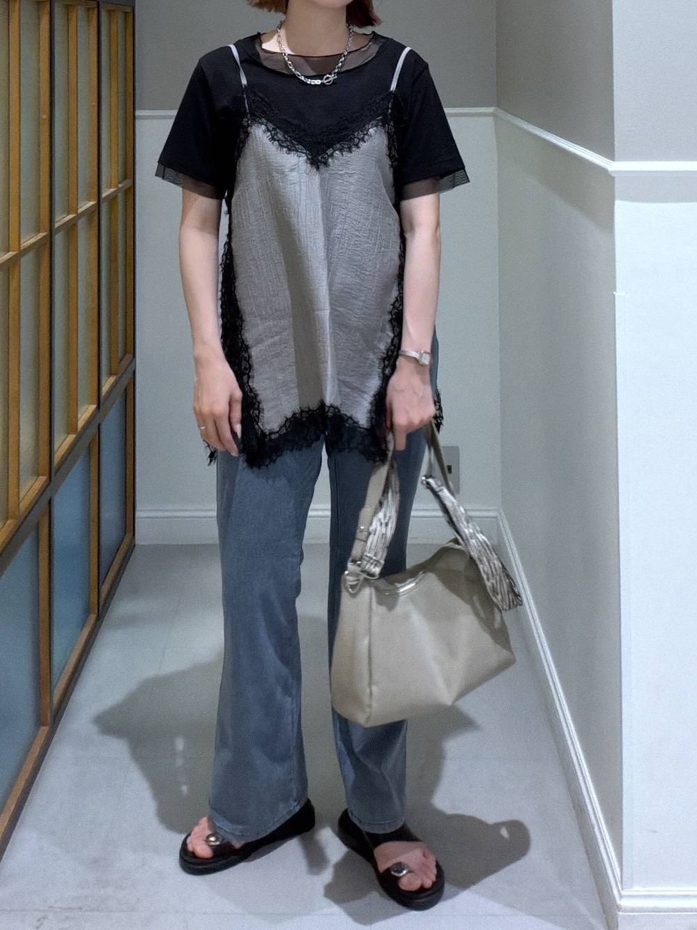 ブラック系のサンダル、ベージュ系のショルダーバッグ、ブラック系のTシャツ/カットソーを着用したレディースの夏コーディネートの1枚目の写真