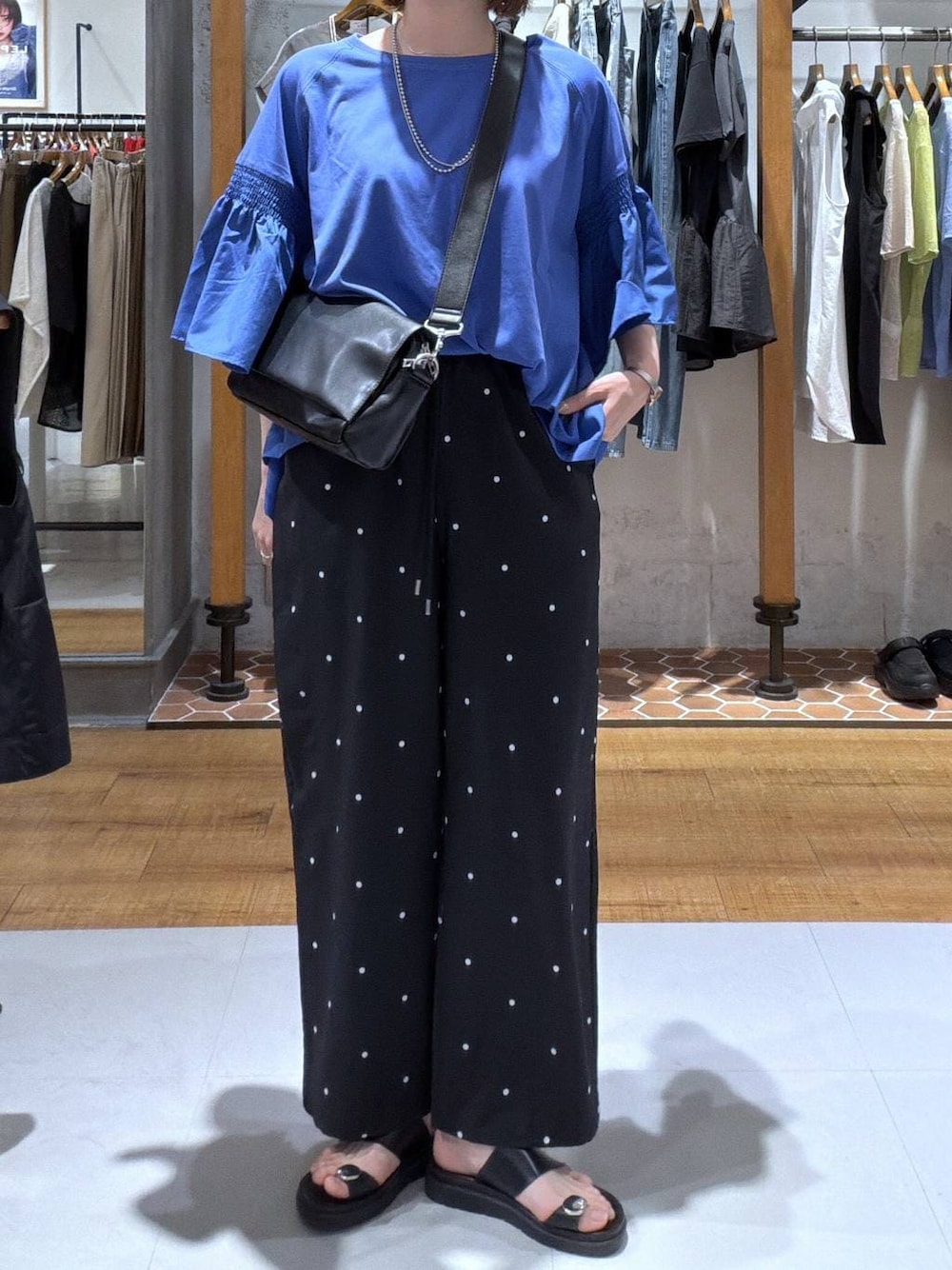 ブルー系のTシャツ/カットソー、ブラック系のショルダーバッグ、ブラック系のサンダルを着用したレディースの夏コーディネートの1枚目の写真