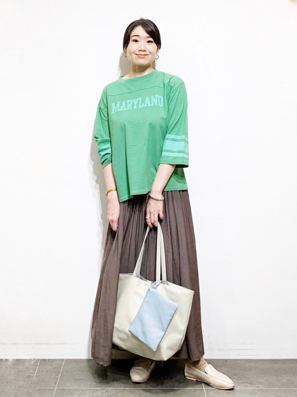 ブラウン系のスカート、ホワイト系のバッグ、グリーン系のその他を着用したレディースの夏コーディネートの1枚目の写真