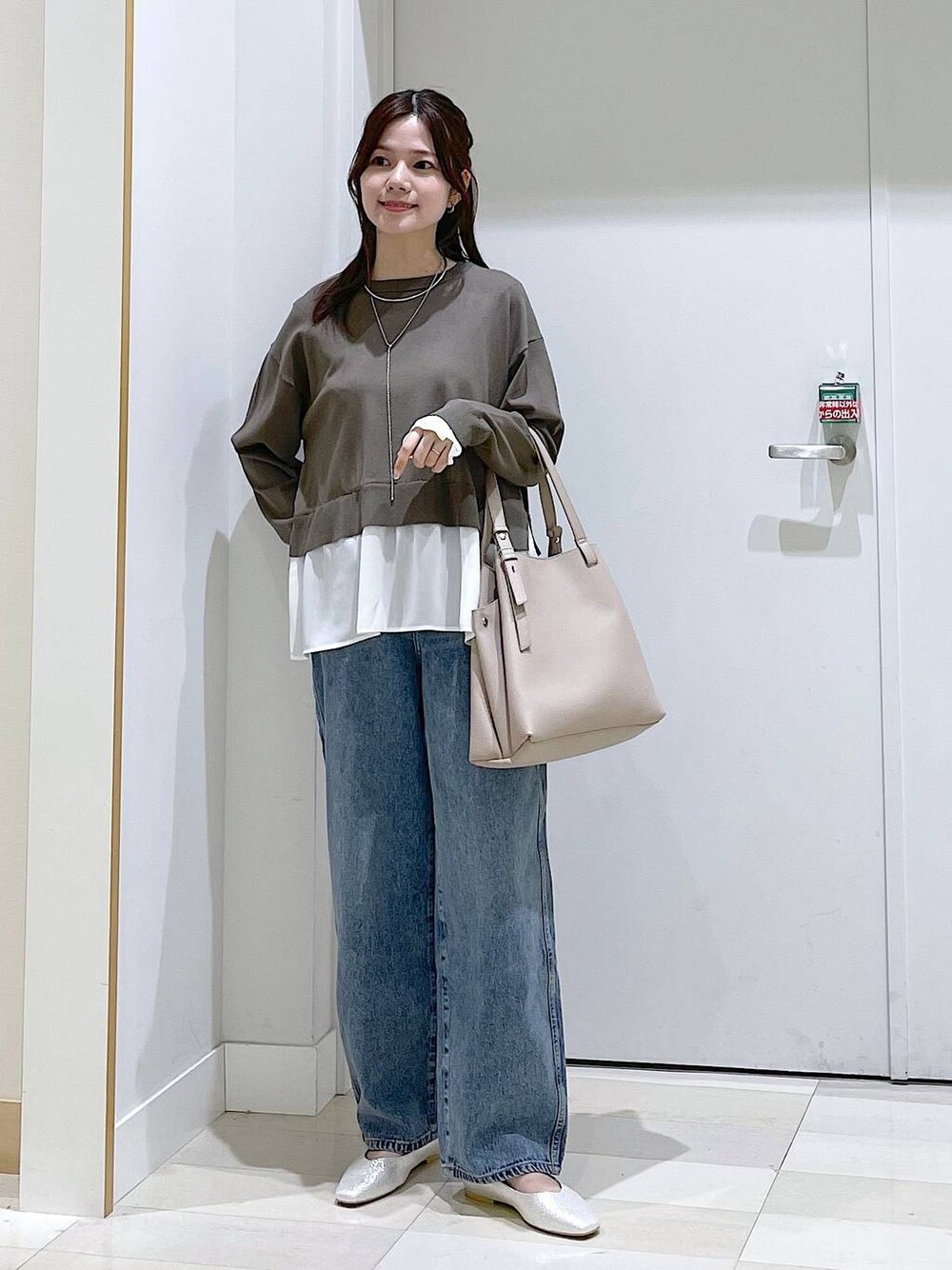 ブルー系のデニムパンツ、ブラウン系のニット/セーター、グレー系のパンプスを着用したレディースの春コーディネートの1枚目の写真