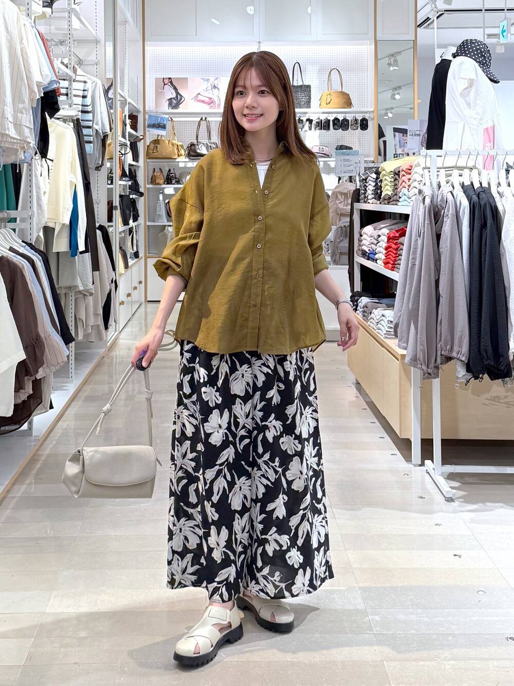 ベージュ系のショルダーバッグ、ホワイト系のタンクトップ、ベージュ系のサンダルを着用したレディースの春コーディネートの1枚目の写真