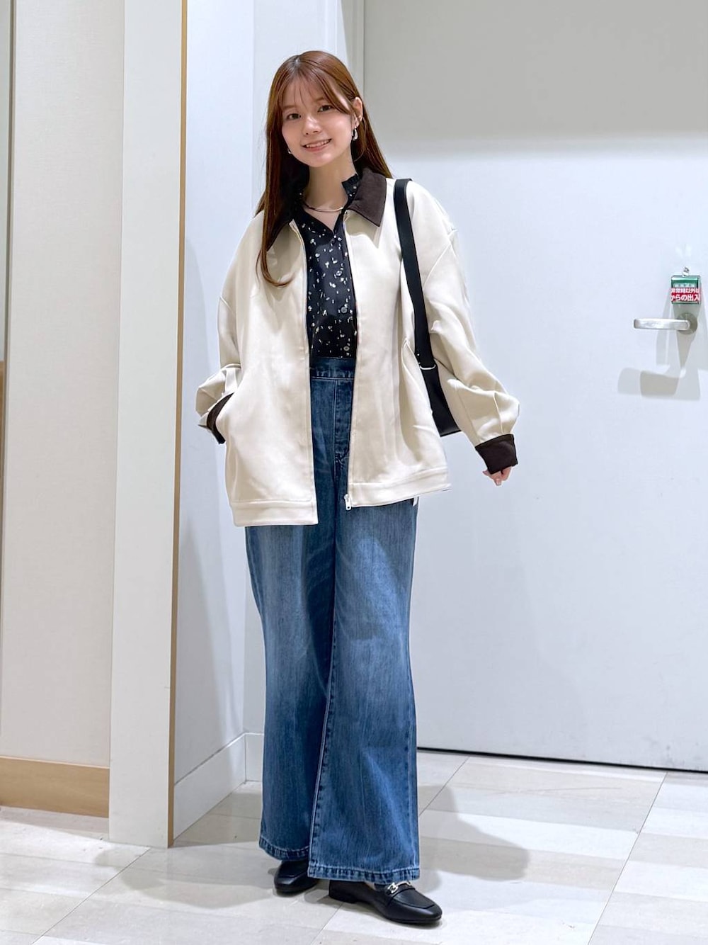 ブラック系のローファー、ブルー系のデニムパンツ、ブラック系のショルダーバッグを着用したレディースの春コーディネートの1枚目の写真