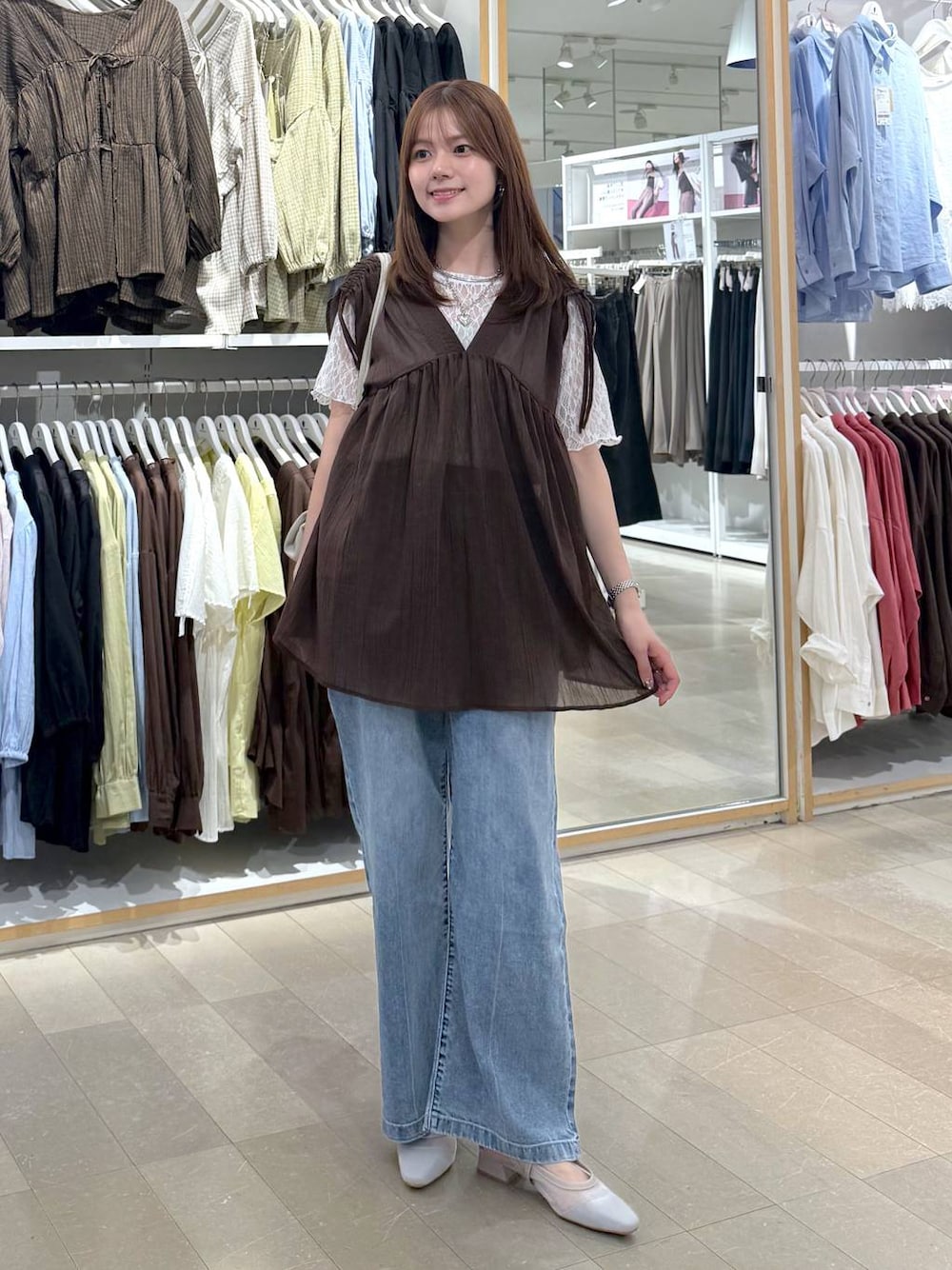 ベージュ系のショルダーバッグ、ブルー系のデニムパンツ、ブラウン系のシャツ/ブラウスを着用したレディースの夏コーディネートの1枚目の写真