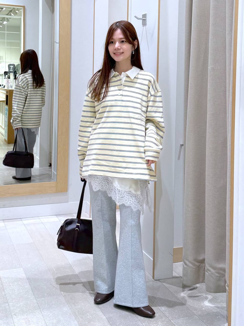 グレー系のスウェットパンツ、イエロー系のスウェット、ブラウン系のショルダーバッグを着用したレディースの春コーディネートの1枚目の写真