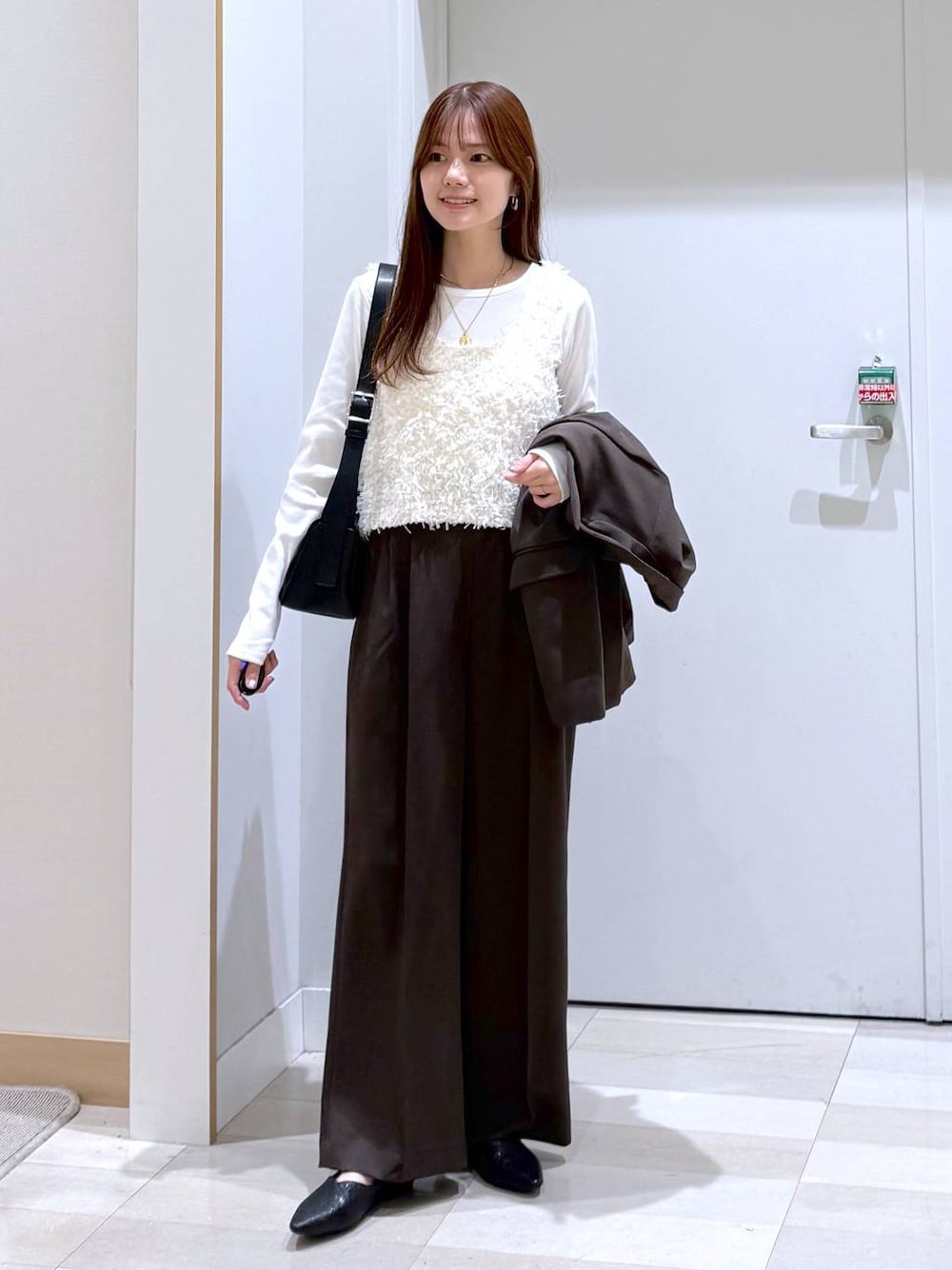 ブラック系のパンプス、ブラウン系のテーラードジャケット、ブラウン系のその他パンツを着用したレディースの冬コーディネートの1枚目の写真