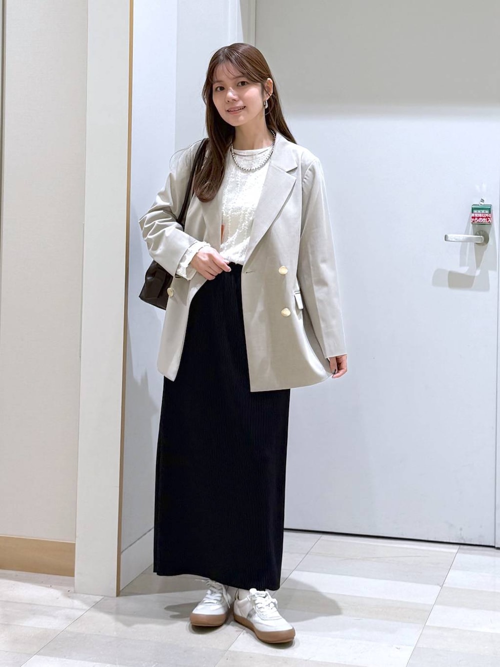 ホワイト系のスニーカー、ブラウン系のボストンバッグ、ホワイト系のTシャツ/カットソーを着用したレディースの春コーディネートの1枚目の写真