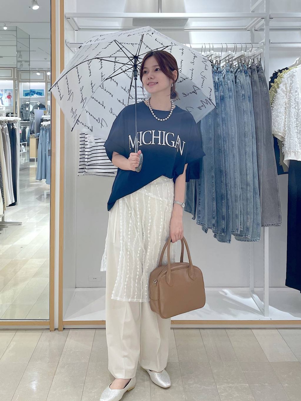 ベージュ系のパンプス、ベージュ系のボストンバッグ、ブルー系のTシャツ/カットソーを着用したレディースの夏コーディネートの1枚目の写真