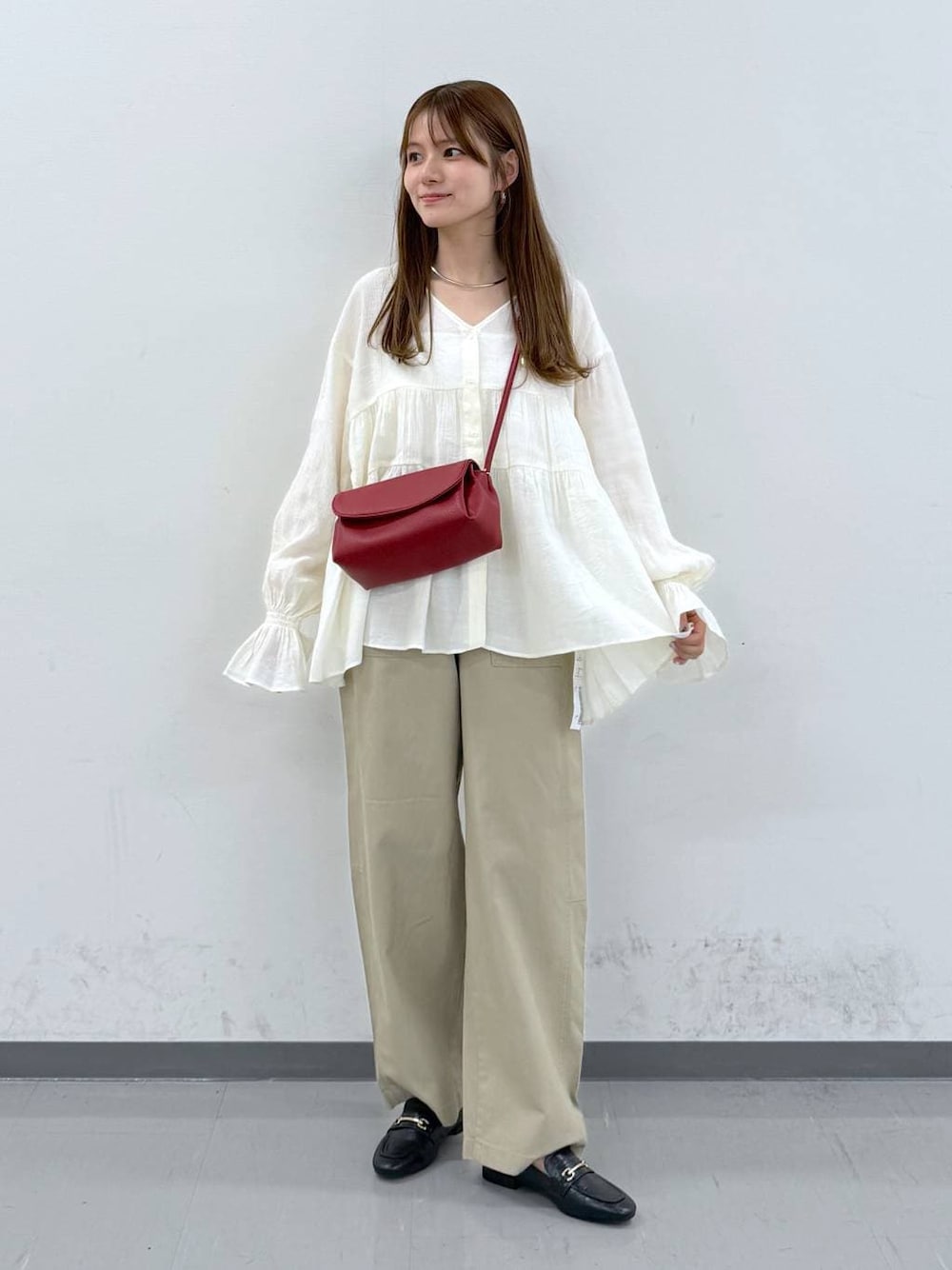 ブラック系のローファー、レッド系のショルダーバッグ、ベージュ系のその他パンツを着用したレディースの春コーディネートの1枚目の写真