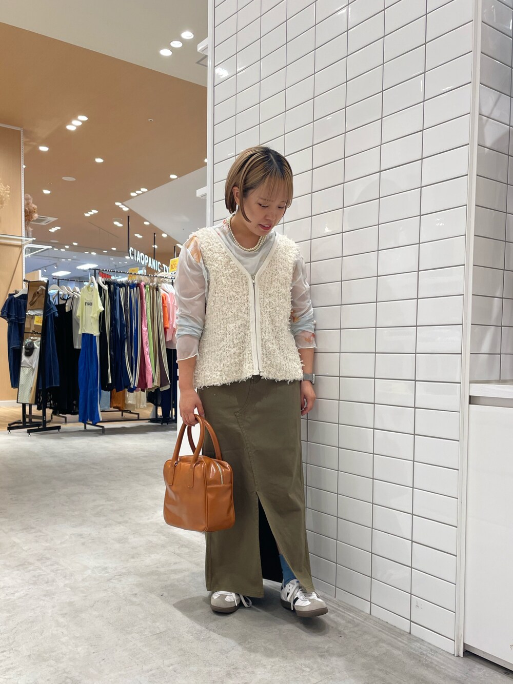 ホワイト系のスニーカー、ホワイト系のTシャツ/カットソー、ホワイト系のベストを着用したレディースの秋コーディネートの1枚目の写真