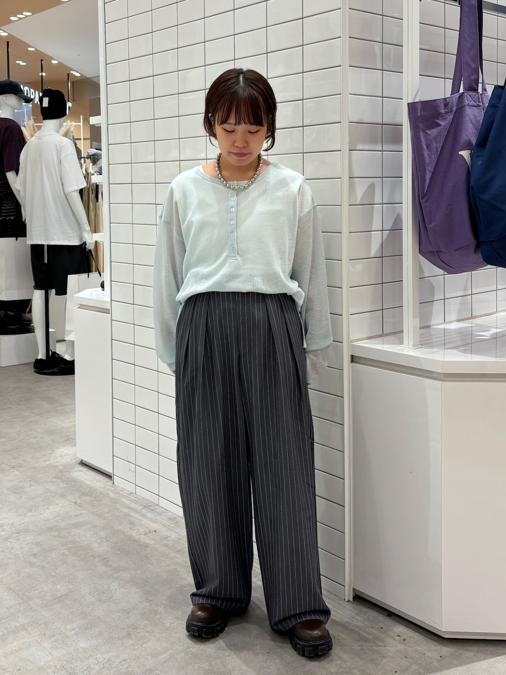 グレー系のスラックス、ブルー系のTシャツ/カットソーを着用したレディースの秋コーディネートの1枚目の写真