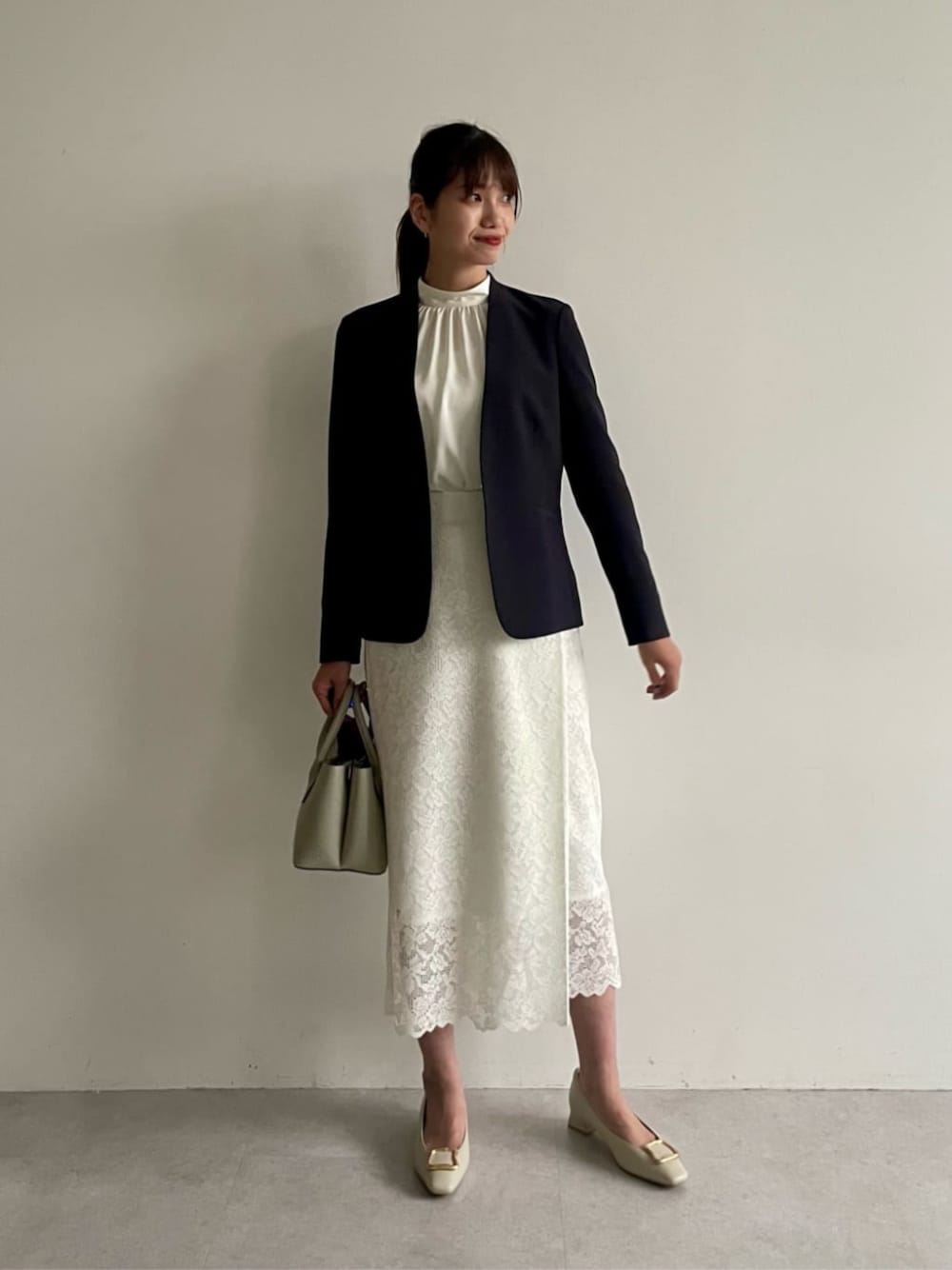 ブルー系のノーカラージャケット、ホワイト系のパンプス、ホワイト系のシャツ/ブラウスを着用したレディースの冬コーディネートの1枚目の写真