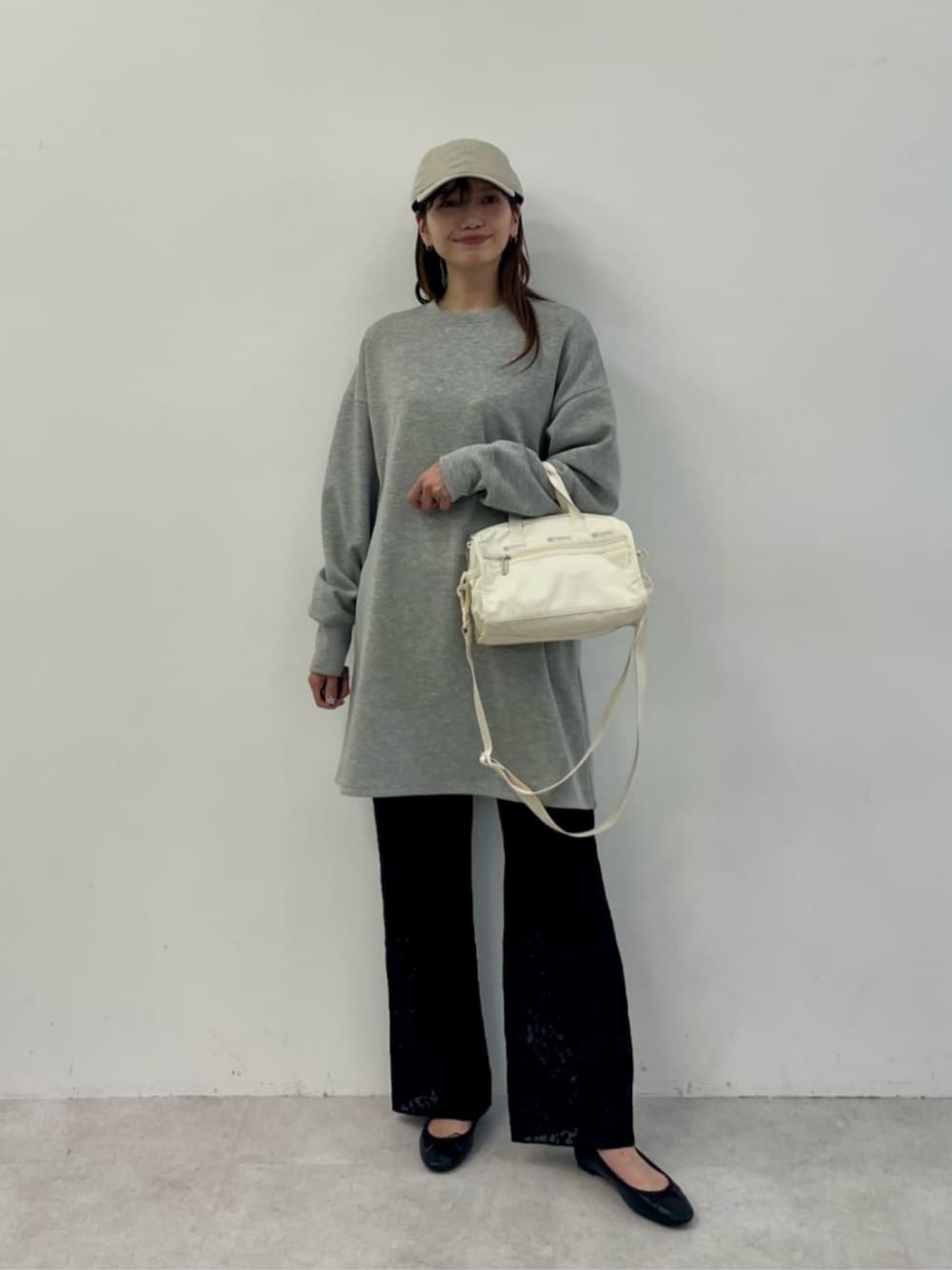 グレー系のスウェット、ホワイト系のショルダーバッグ、ブラック系のその他パンツを着用したレディースの冬コーディネートの1枚目の写真