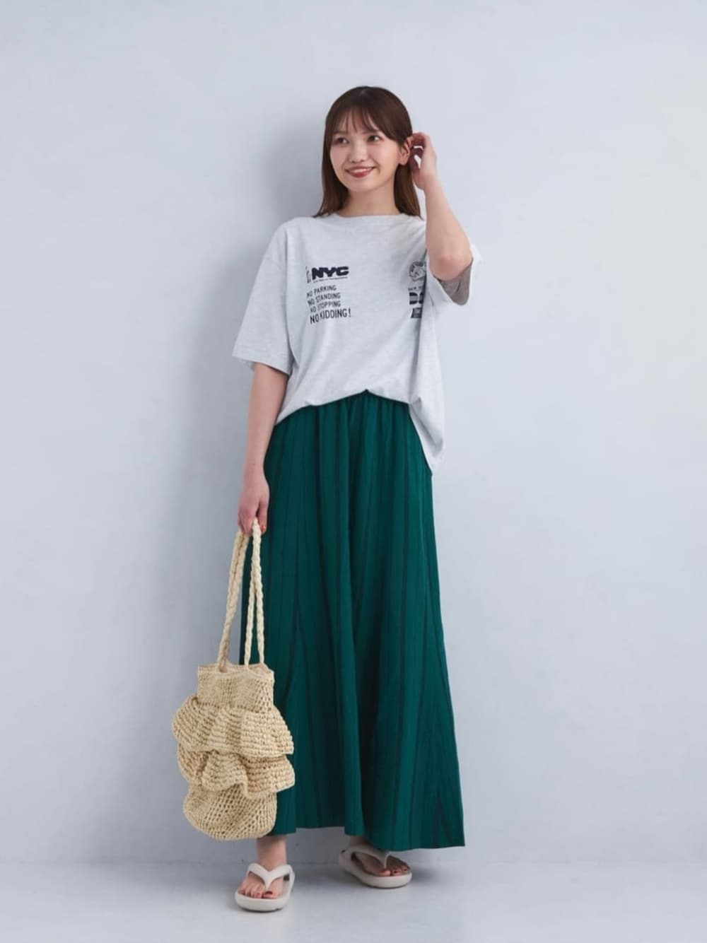グレー系のTシャツ/カットソー、グリーン系のスカート、グレー系のサンダルを着用したレディースの夏コーディネートの1枚目の写真