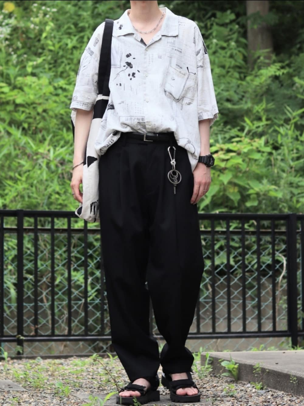 「アロハシャツ、モノトーン、スラックス、テーパードパンツ、ドメスティックブランド、キーリング、トートバッグ、サンダル、夏コーデ、柄シャツ、アクセサリー、腕時計、タックイン、オーバーサイズ、ベルト」｜「Hender Schemeのwebb（その他シューズ、ブラック系）」を使った、マサラティさん（メンズ・173cm）の夏コーディネートの1枚目の写真