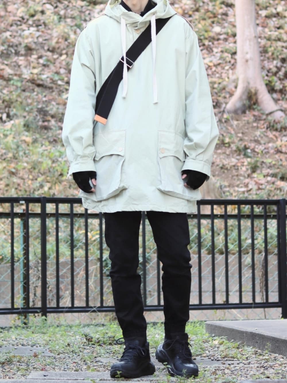 ブラック系のデニムパンツ、ホワイト系のその他アウター、ブラック系のスニーカーを着用したメンズの冬コーディネートの1枚目の写真